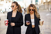 Young businesswomen using phone outdoors
