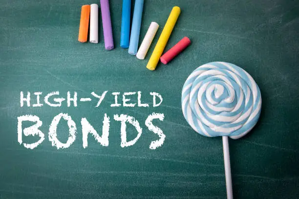 Photo of High-Yield Bonds. Colored pieces of chalk on a green chalkboard background