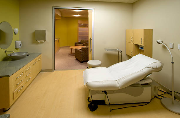 Empty doctor's office with white furniture and examination table