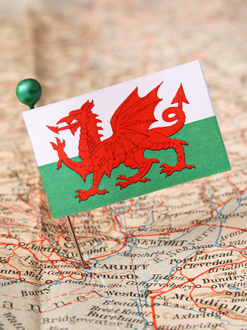 Welsh paper flag over more than 50 years old map pointing Cardiff