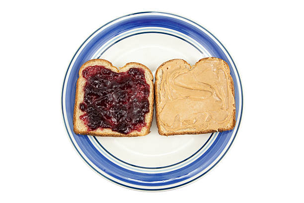 Peanut Butter and Jelly on Plate Peanut butter and jelly on wheat bread, on a plate isolated on white. peanut butter and jelly sandwich stock pictures, royalty-free photos & images