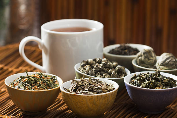 Hot Tea and Leaves, Tasting of Variety of Green and Black Tea Subject: A selection of tea from around the world, including Japanese green tea with roasted rice, Jasmine, Chinese green tea, English Breakfast, Indian Darjeeling, Oolong. oolong tea stock pictures, royalty-free photos & images