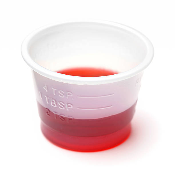 Cold or Cough Syrup Medicine - Child Dose 2t Two teaspoons of liquid cold or cough medicine. dose stock pictures, royalty-free photos & images
