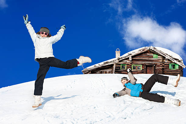 Girl jumping in front of a log cabin in Bavarian Alps