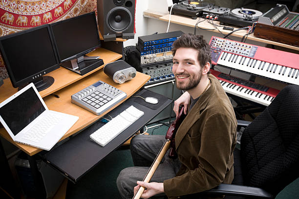 istock Aspiring Young Male Musician in Studio with Guitar, Computers, Keyboards 157418925