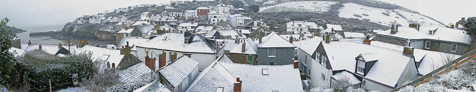 A panoramic view of the Cornish fishing village of Port Isaac taken after an unusual snow fall.This picture was taken from the West side of the village and shows a rooftop view of virtually the whole community. The harbour is on the left hand side.