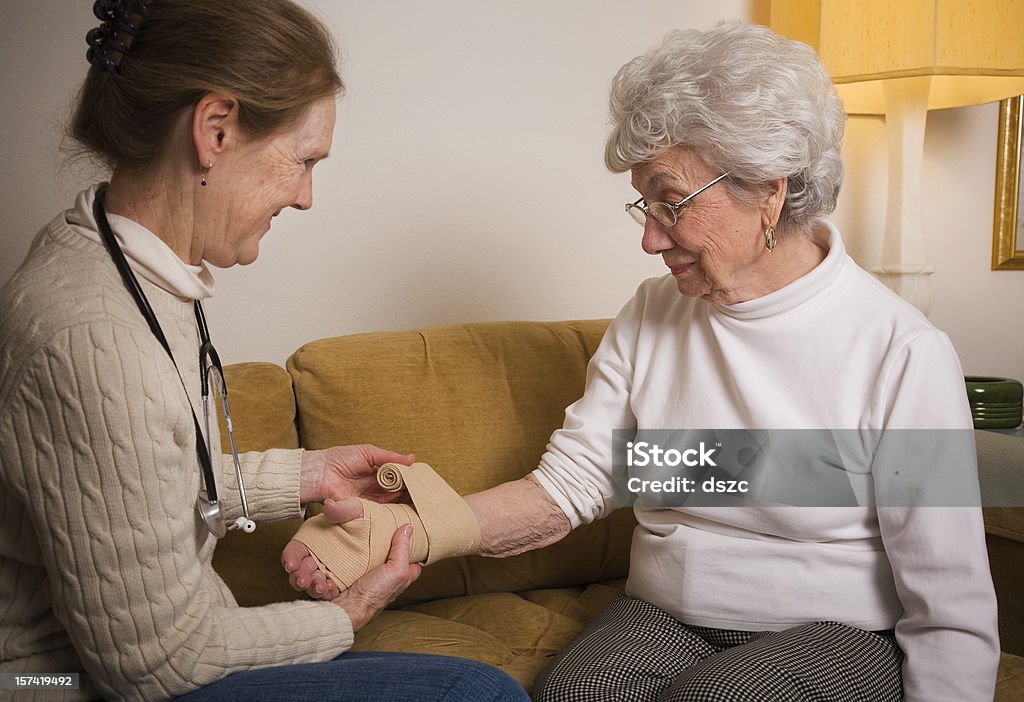 Home healthcare professionellen Einwickeln Handgelenk von Ältere Frau - Lizenzfrei Elastische Binde Stock-Foto