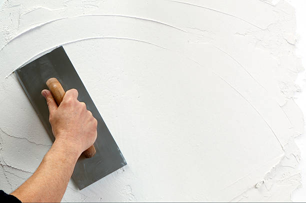 plaster application hand holding plastering tool plaster stock pictures, royalty-free photos & images