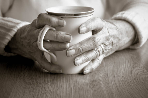 Hand holding enamel mug out of house window in the morning