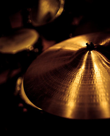 cymbals in golden sepia, low light and shallow DOF