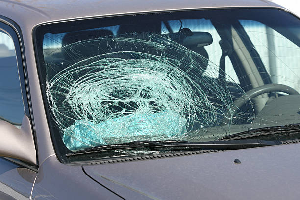 Broken windshield on a grey car stock photo