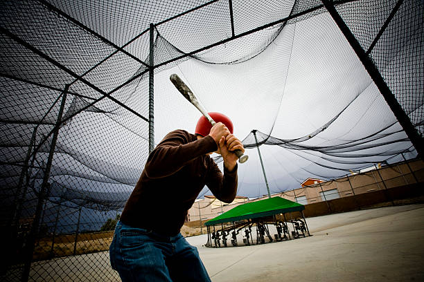 Baseball Practice: Man at Batting Cages Batting Cages baseball cage stock pictures, royalty-free photos & images