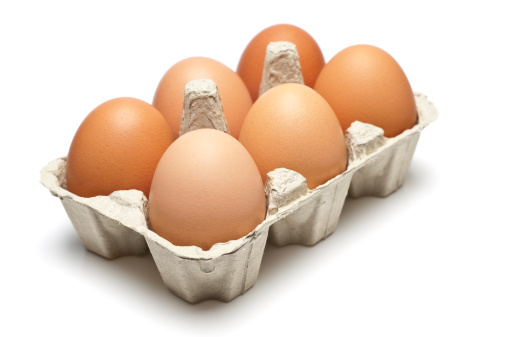 A carton of six eggs isolated on white