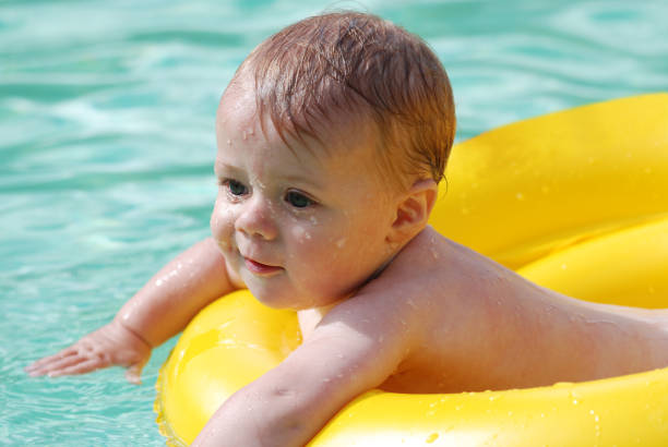 a baby boy of about 8 months in the swimming pool on a hot summers day.