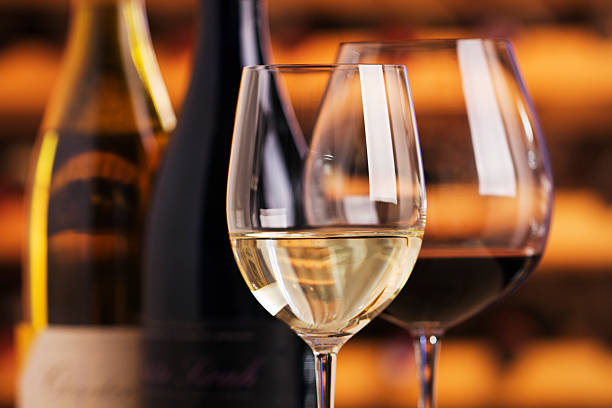 rosso e vino bianco con occhiali e bottiglie, cantina di sfondo - bicchiere da vino foto e immagini stock