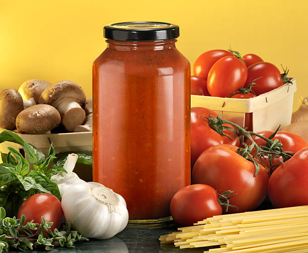 Bottled pasta sauce with raw ingredients stock photo