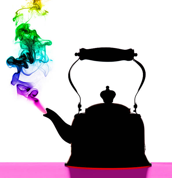 A close-up of a kettle boiling on a fire. There's smoke coming out from the kettle as well as from the fire.