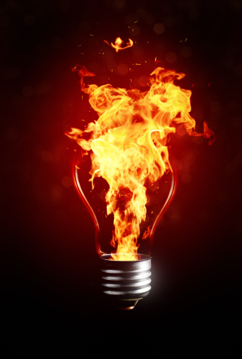 Hot idea. Abstract light bulb with flame in it on dark red background