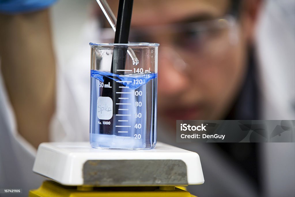 Químico en laboratorio enfoque en primer plano el vaso de precipitados - Foto de stock de Planta de depuración de aguas residuales libre de derechos