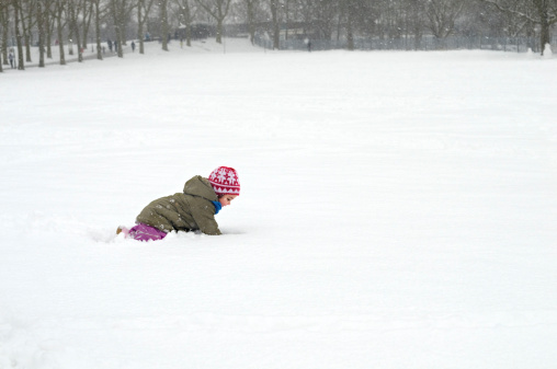 Poznan, Poland – January 30, 2021: Kids and adults having fun with snow at a park on a cold winter day