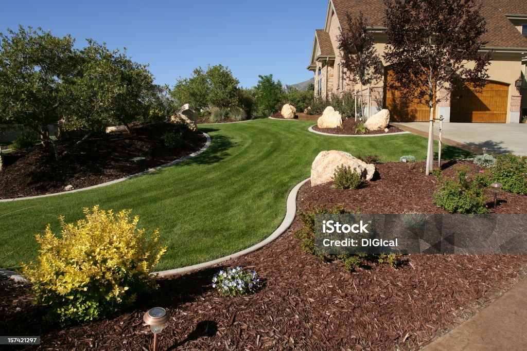 Landscape A nicely landscaped front yard, with a new, beautiful updated home. Landscaped Stock Photo