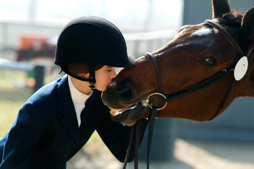 Teenage Girl in helmet Learning Horseback Riding