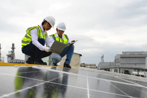 Young Engineers and Technicians Discuss and Check Quality of Installing Solar Photovoltaic Panels and Use App Technology Checking Accumulated power generation from Solar Panel on Tablet and Laptop. jóvenes ingenieros y técnicos discuten y verifican la calidad de la instalación de paneles solares fotovoltaicos y usan la tecnología de aplicaciones verificación de la generación de energía acumulada del panel solar en tableta y computadora portát
