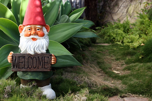 Classic garden gnome with welcome sign