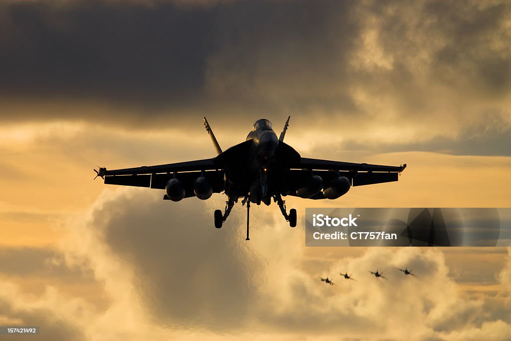 Fighter Jet Landing A naval jet fighter on approach for landing as more jets approach overhead. Fighter Plane Stock Photo