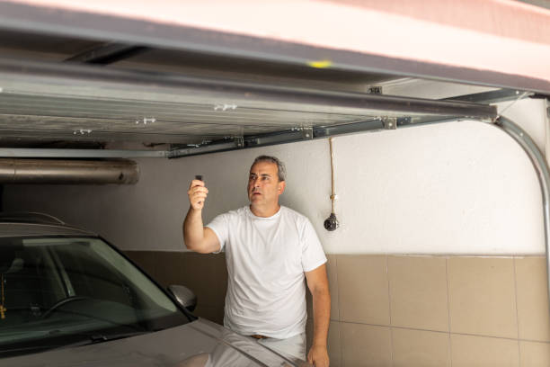 istock Man closing garage door after parking his car 1574215603