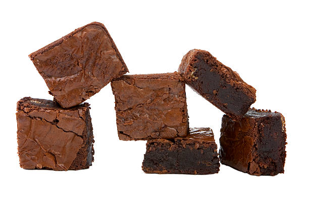 Chocolate brownies stacked in front of a white background stock photo