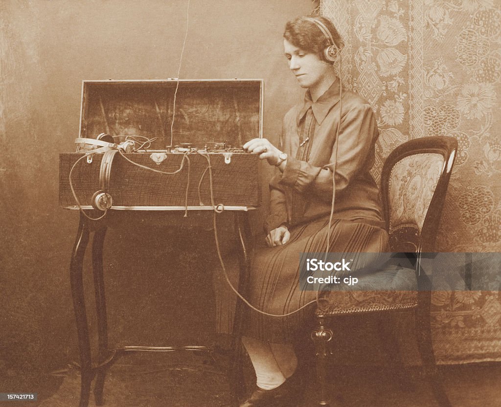 Wartime Morse Code Communications Vintage Victorian sepia image of a woman using a morse code radio communications device housed within an oak box. Telegraph Machine Stock Photo