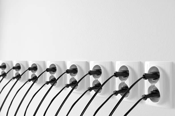 istock Group of wall outlets with black plugs, cables stucked in 157421889