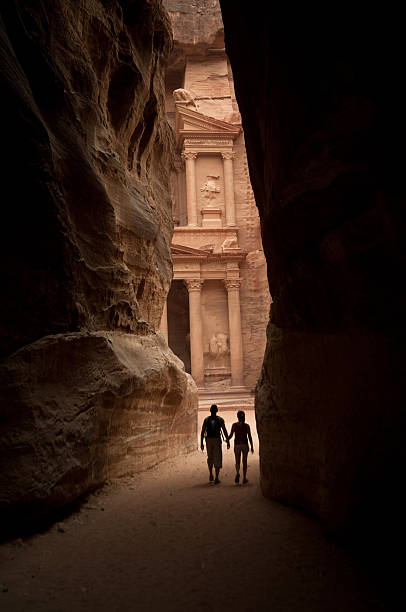 Two figures approach the lost city of Petra stock photo