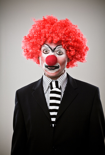 Mr Clown. Portrait of Funny shocked face comedian Clown man in colorful costume wearing wig standing posing smiling to camera. Happy expression amazed bozo in various pose on isolated background.