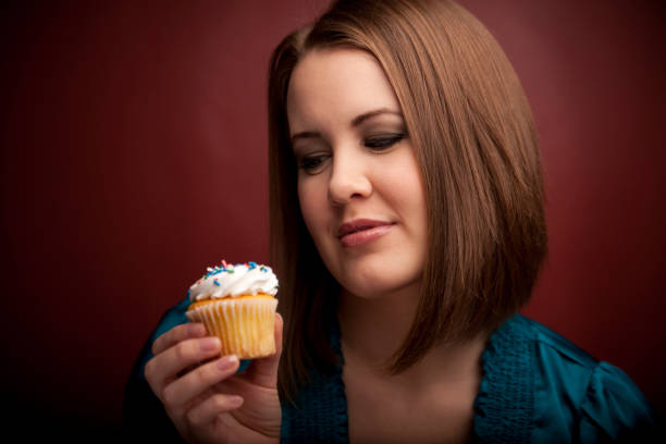 istock Girl looks at cupcake intently 157422413