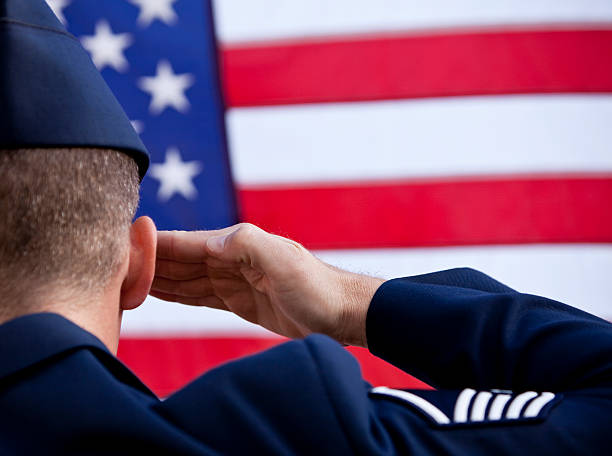 Soldier saluting American flag US serviceman in dress uniform saluting the flag. air force salute stock pictures, royalty-free photos & images