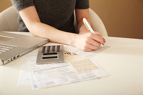 Paying Bills Woman paying bills at home mergers and acquisitions photos stock pictures, royalty-free photos & images