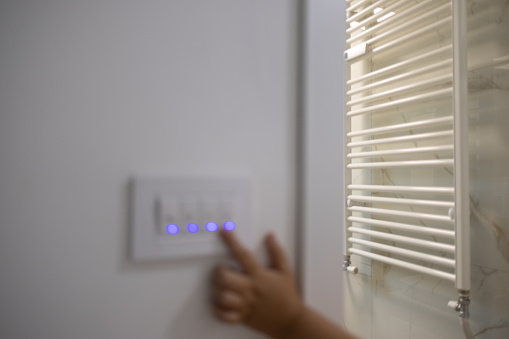 light switch in a dimly lit room, symbolizing the concept of electricity conservation and energy-saving practices in everyday life