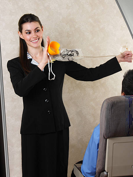 Flight Attendant Demonstrating Oxygen Mask  oxygen mask plane stock pictures, royalty-free photos & images