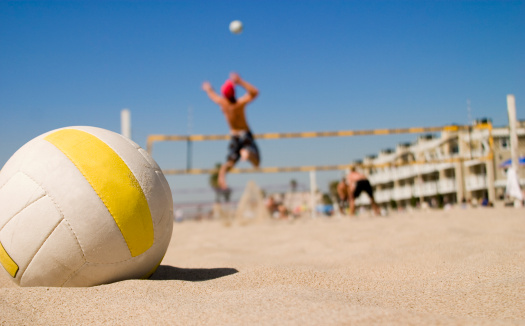 Beach volleyball court with a volleyball ball placed in the sand.