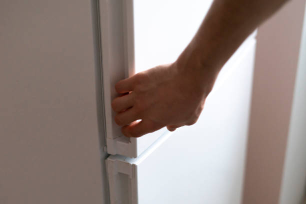 istock hand opens fridge in the kitchen to take some food 1574236385
