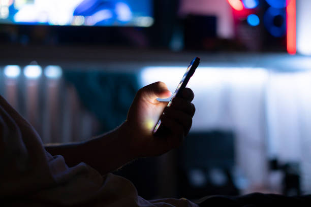 istock person holding smartphone and scrolling on web page at night 1574236925