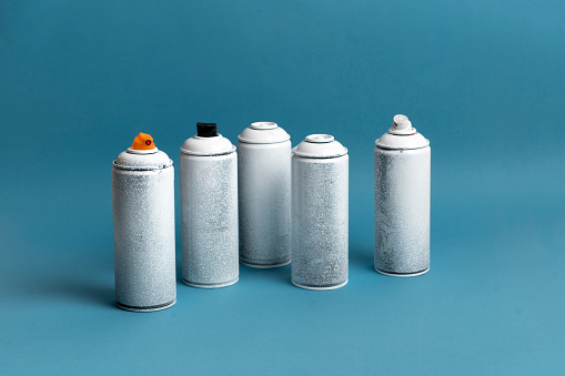 Spray cans on blue background