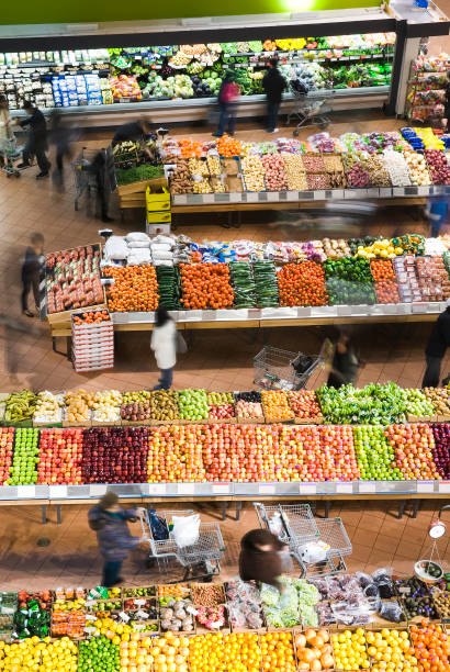 A display of fresh produce of vegetables and fruits in a grocery store supermarket refrigerator shelves case. A retail market environment. A large variety of food items are beautifully organize for the customer. Photographed on location in horizontal format.