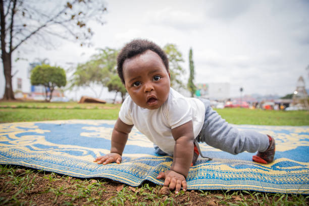 istock An African newborn with a surprised look crawls on a picnic tablecloth 1574240868