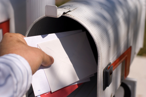 White Mailboxes in an apartment residential building at window with sun flare background. Backdrop of rows of numbered mailbox in residential apartment build. Correspondence concept. Copy text space