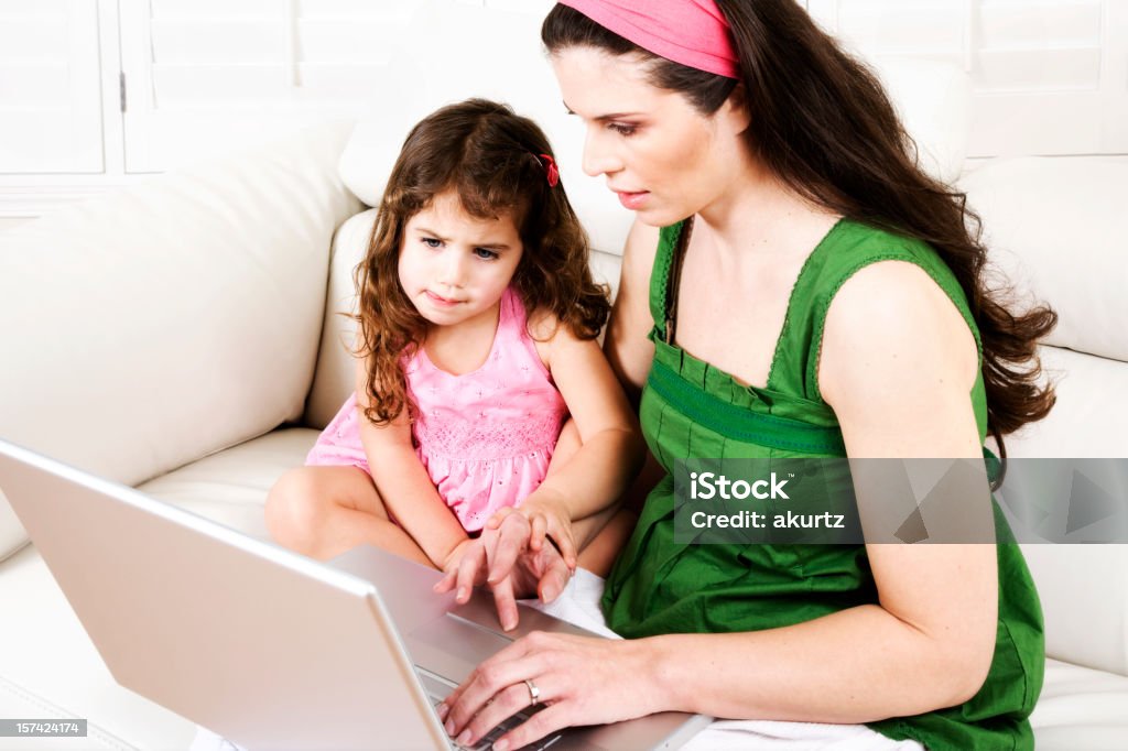 Mãe e filha laptop em casa sofá de couro de aprendizagem - Foto de stock de 2-3 Anos royalty-free