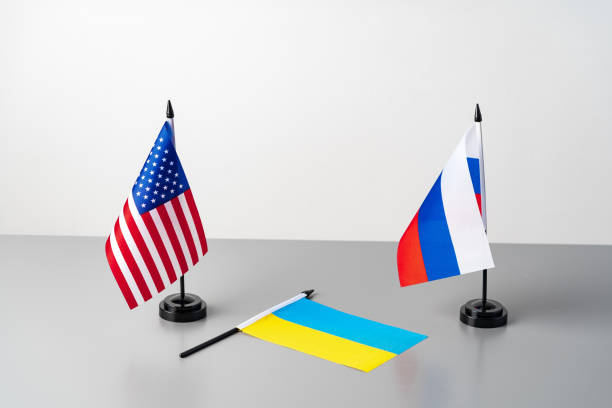 istock Ukraine, USA and Russia flags on gray table 1574242586