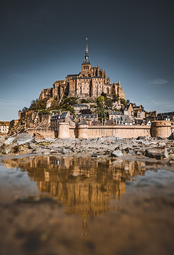 A picturesque view of Mont Saint Michel, an island commune in France, from the banks of the river